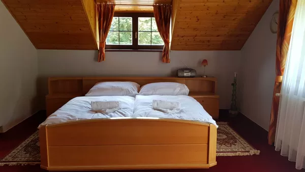 Pokoj s manželskou postelí, koupelnou a balkonem.